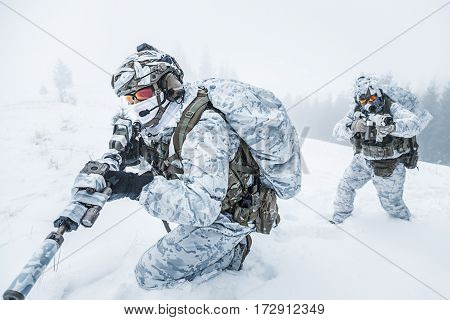 Winter arctic mountains warfare. Action in cold conditions. Pair of special forces weapons in forest somewhere above the Arctic Circle