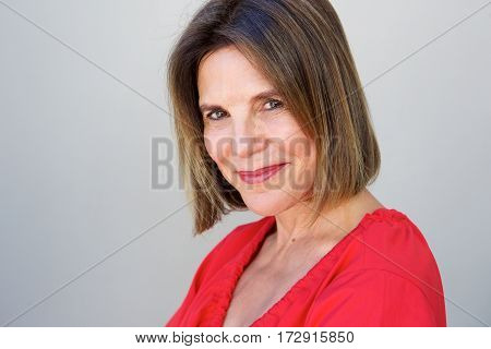 Attractive Older Woman Smiling Against Gray Background