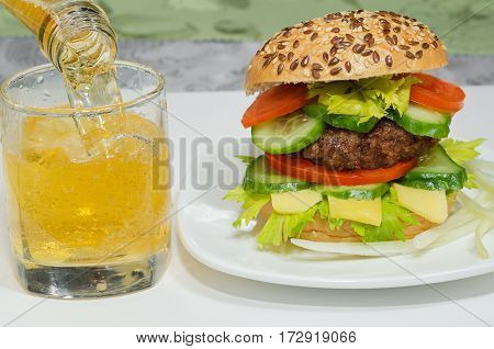 Great Burger and beer is poured into a glass close-up.
