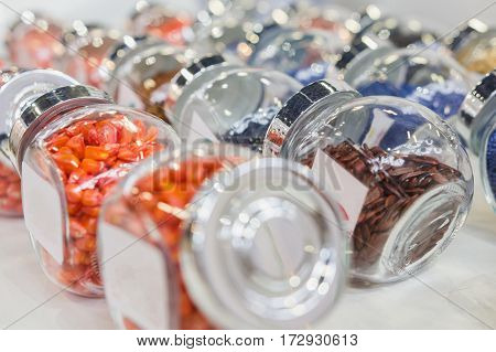 Colorful pills in the glass bottles - chemistry and pharmaceutical concept, close up