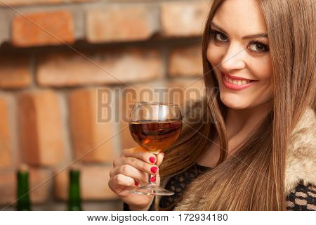 Woman Tasting Wine In Rural Cottage Interior