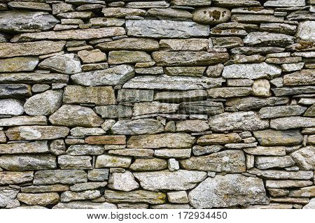 Textures and patterns consept. Detailed closeup background wall made of grey stone rocks.