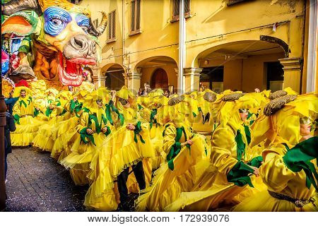 Cento Italy 19 feb 2017: Carnevale di Cento colorful cow parade float with people choreography in yellow sunflower costumes