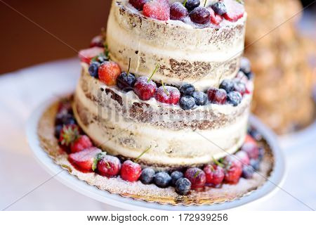 Delicious Chocolate Wedding Cake Decorated With Fruits And Berries