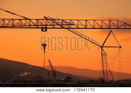 Construction of the building. Construction crane on the sunset background