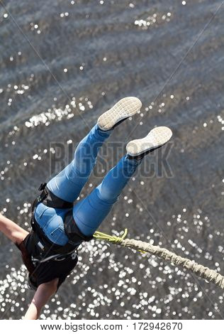 Girl tied a rope to jump off a bridge. Extreme sport