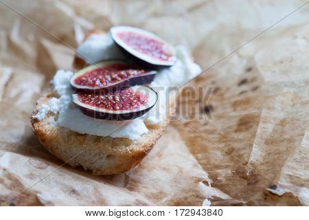 Bruschetta with ricotta chease and figs on list of parchment