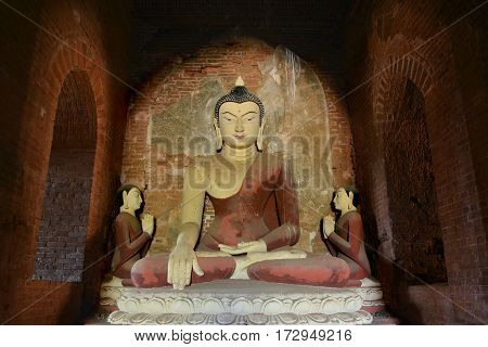 Ancient big Buddha statue sitting in meditation inside old pagoda in Bagan, Myanmar