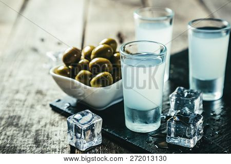 Traditional Greek Vodka - Ouzo In Shot Glasses On Rustic Wood Background