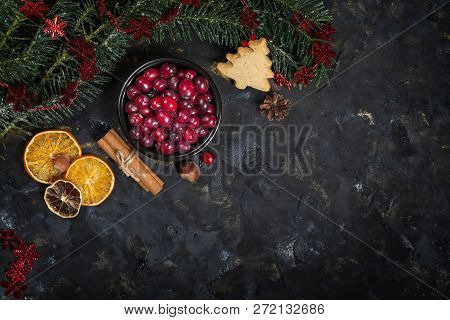 Christmas Background With Christmas Tree Branch, Dry Oranges, Sticks Of Cinnamon And Bowl Of Fresh C