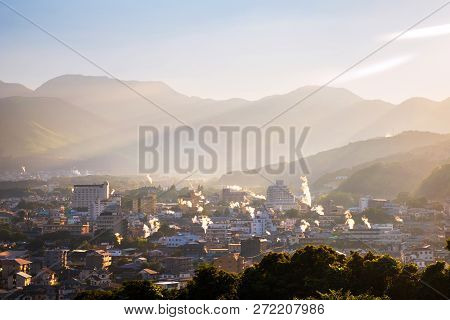 A Sunset In A Resort Town Of Beppu, Japan, With A View Of Mountains Embracing The City And Layers Of