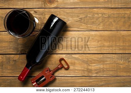 Bottle Of Wine Glass And Corkscrew On Wooden Background. Top View With Copy Space.