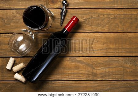 Bottle Of Wine Glass And Corks On Wooden Background. Top View With Copy Space.