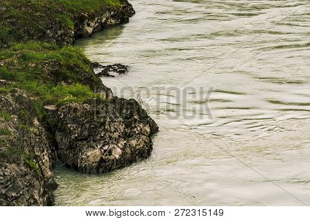 Gloomy View From Above On Rocky Sinuous Riverbank. Dark Green Of Water. Eerie Atmosphere In Overcast