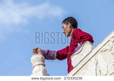 A Nun In Lharong Monastery And The Monk Houseson Surrounded In Sertar, Tibet.  Lharong Monastery Is 