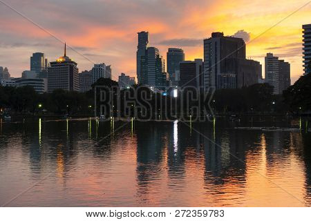 Bangkok City Beautiful Skyline At Dusk, Viewing From Lumphini Park With Tourist Are Traveling Here.