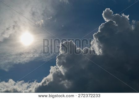 The Sun Shines Brightly In The Clear Blue Sky. Big Storm Clouds Are Coming. Cumulus Clouds Before Ra