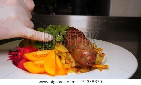 The Finished Dish With Kebab Meat And Potatoes Is Decorated With Greens And Vegetables. The Concept 