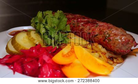 The Finished Dish With Kebab Meat And Potatoes Is Decorated With Greens And Vegetables. The Concept 