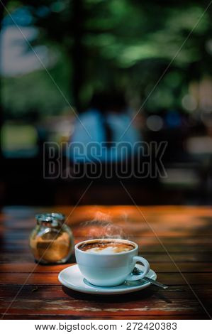 Hot Coffee Latte Cappuccino Spiral Foam On Wooden Table In Coffee Shop Cafe With Vintage Color Tone 