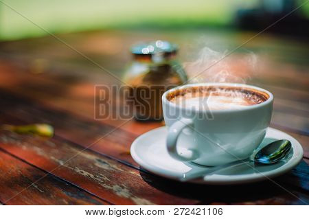 Hot Coffee Latte Cappuccino Spiral Foam On Wooden Table In Coffee Shop Cafe With Vintage Color Tone 