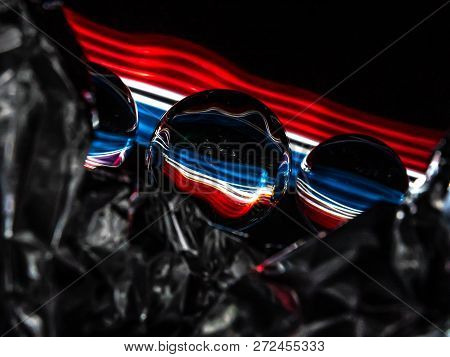 A Ribbon Of Red, White, And Blue Are Visible Through The Reflections Of The Lensballs And The Abstra