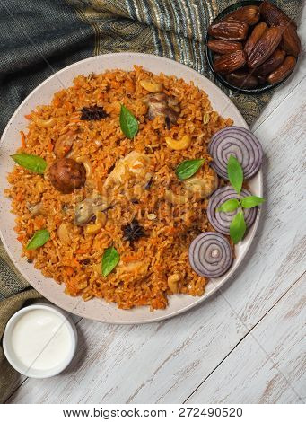 Homemade Chicken Biryani Served With Yogurt Dip And Dates. Arabian Food.