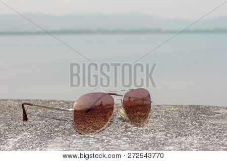 Fashion glasses on the cement floor, with sea background.
