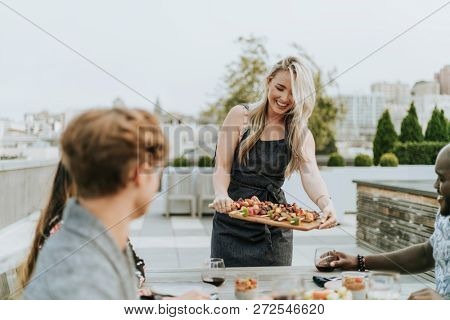 Woman serving vegan barbecue to her friends