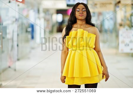 Stylish African American Woman At Yellow Dreess Posed At Mall.