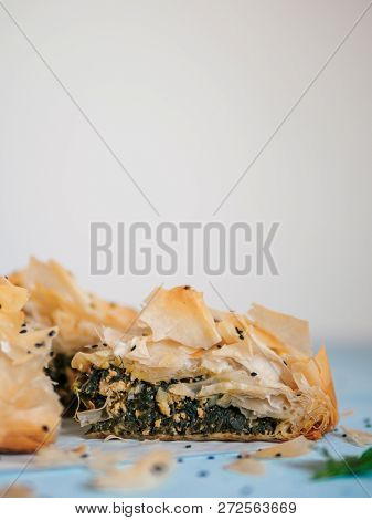 Greek Pie Spanakopita On Blue Table With Shallow Dof. Slice Of Vegetarian Or Vegan Spanakopita Spina