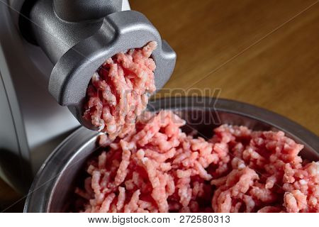 Minced Meat Coming Out From Modern Electric Grinder On Oak Table As Background. Healthy Fresh Homema