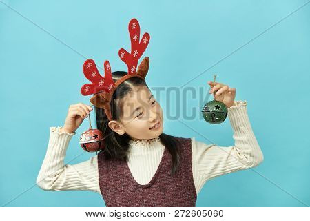 Asian Girl With A Christmas Concept Headdress Child, Close Up Of Cute Little Asian Girl On Blue Back