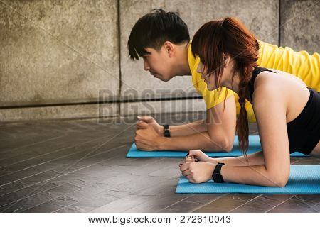 Asian Couple In Sportwares  Doing Planking Exercise Outdoor.