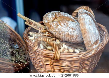 Bread Loaves And Baguettes In A Wicker Basket.