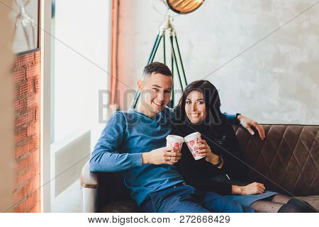 Beautiful Couple Sitting At Romantic Atmosphere Looking Each Other, Talking, Smiling And Drinking Wa