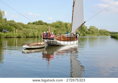 Norfolk, Uk - September 6,2018: Vintage Style Sail Boat Towing A Small Rowing Boat On The Norfolk Br