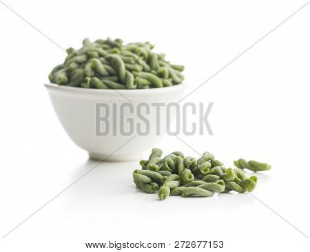 Uncooked spinach gemelli pasta isolated on white background.