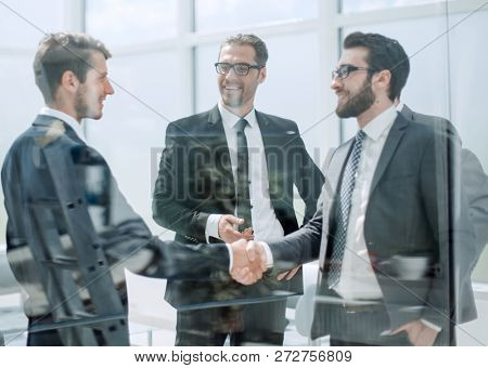 business partners shaking hands in the lobby of the business cen
