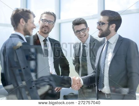 business partners shaking hands in the lobby of the business cen