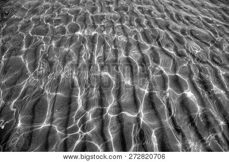 Background Sandy Bottom Through Clear Water. Light Lines.