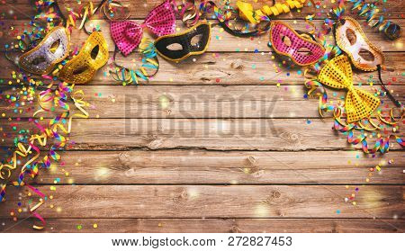 Colorful carnival or birthday background with masquerade masks on wooden background