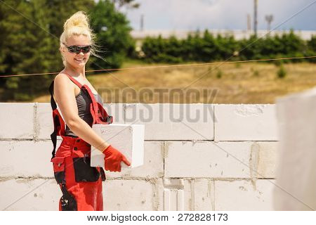 Strong Pretty Woman Working On Construction Site, Building House, Installing Gray Airbricks. Industr