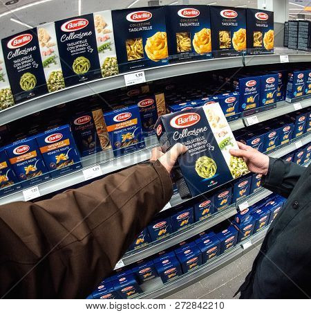 Frankfurt, Germany - Mar 5, 2017: Pov Man And Woman Buying Barilla Pasta Tagliatelle Con Spinaci Bol
