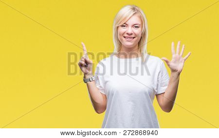 Young beautiful blonde woman wearing white t-shirt over isolated background showing and pointing up with fingers number six while smiling confident and happy.