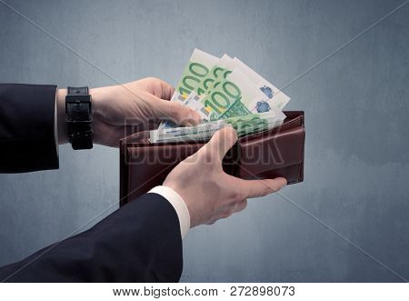 Businessman's hand in suit takes out eruo from his wallet
