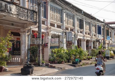 Kampot, Cambodia - 12 April 2018: Town View With French Colonial Buildings And Khmer Woman On Scoote