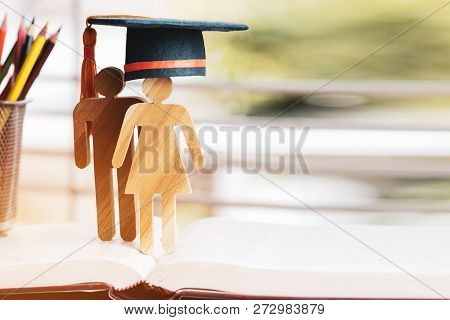 Back To School Concept, People Sign Wood With Graduation Celebrating Cap On Open Textbook With Light