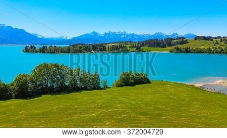 Aerial View Over Lake Forggensee At The City Of Fuessen In Bavaria Germany
