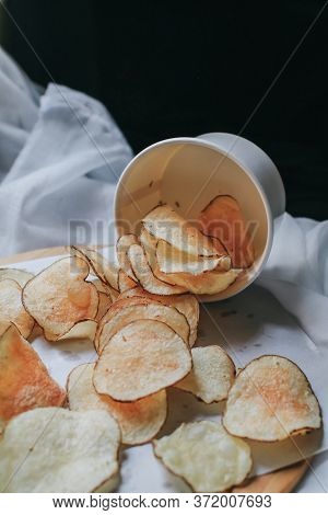 Fresh Homemade Deep Fried Crispy Potato Chips In White Box On A Wooden Tray, Top View. Salty Crisps 